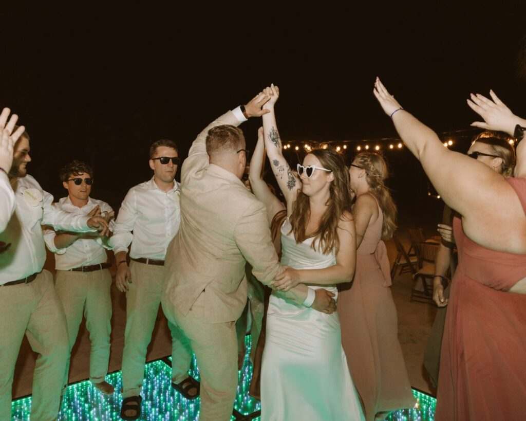 the bride and groom dancing together surrounded by their bridal party