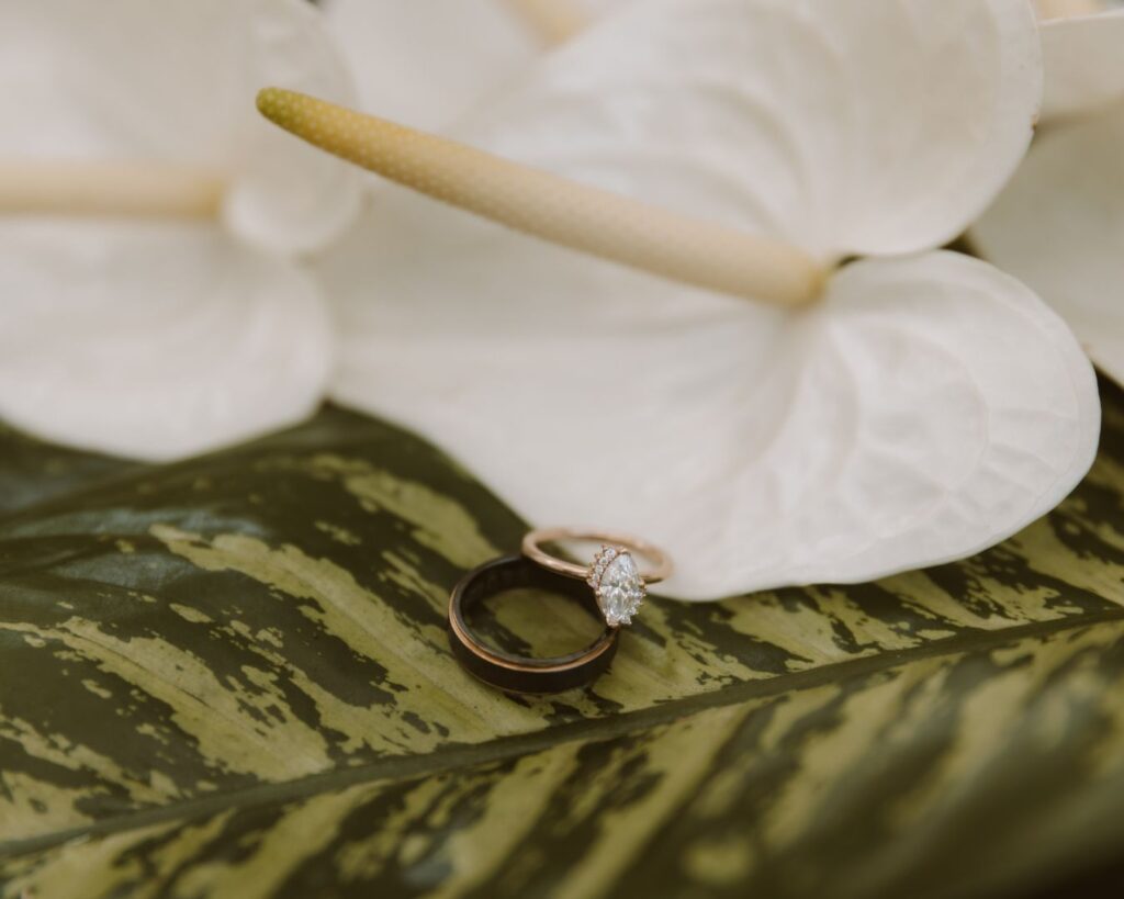 Bride and groom's rings laid within the bride's tropical dress. 