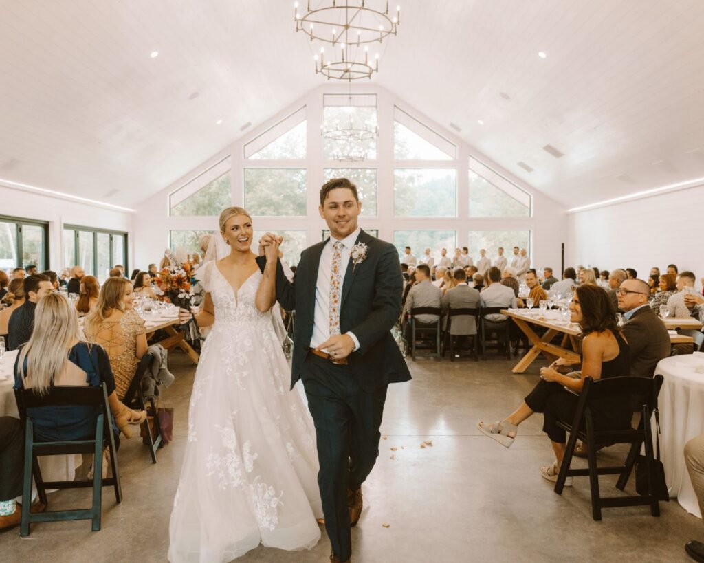 Bride and groom making their way down the aisle surrounded by their guests after being announced and husband and wife for the first time. 