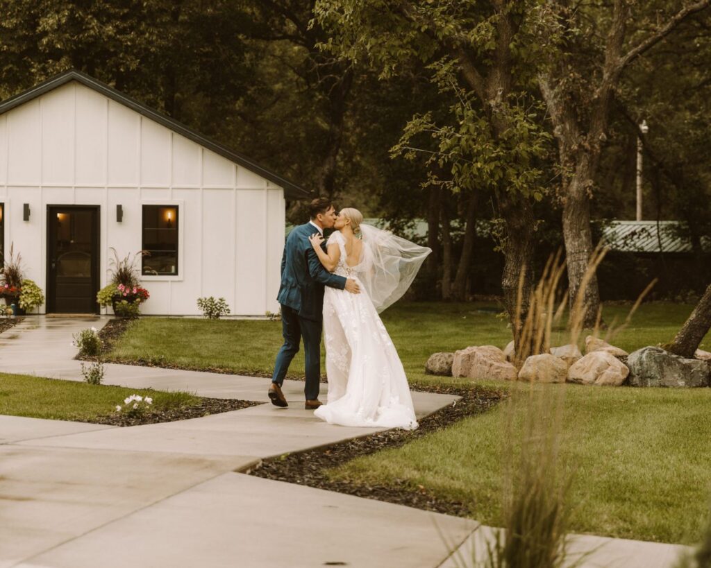 Groom stealing a quick kiss from the bride as they walk outside from their wedding ceremony to the bridal suite. 