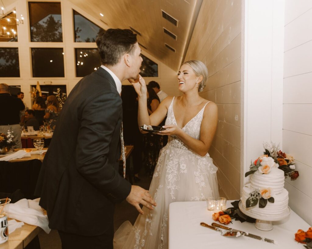 The bride feeding the groom their cake during their wedding reception,. 