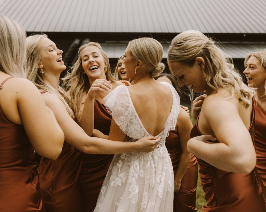 The bridesmaids hugging the bride all together after seeing her in her dress in the first time. 