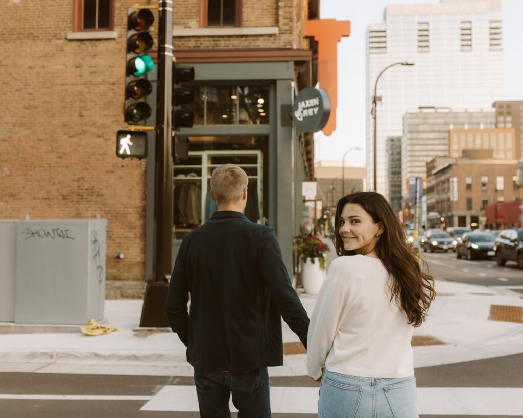 Image of an engaged couple crossing  a city street when the light gave the walk signal