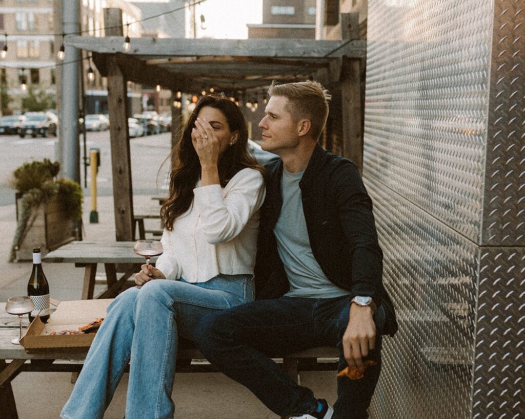 Engaged couple suggled up on a picnic table in the city 