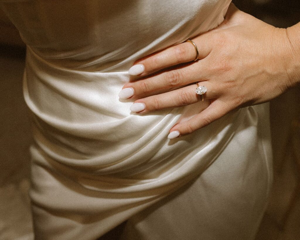 up close image of the brides ring as she places her hand on her hip