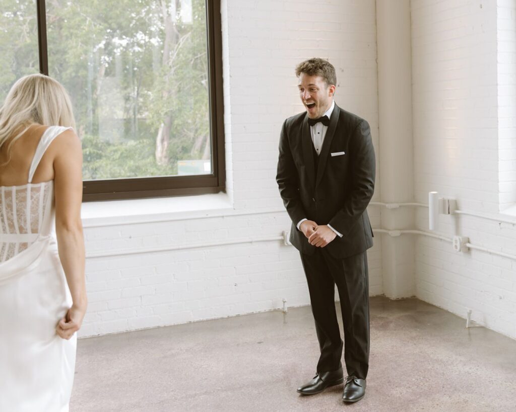 the groom's face in shock and awe as he his seeing his bride for the first time on their wedding day