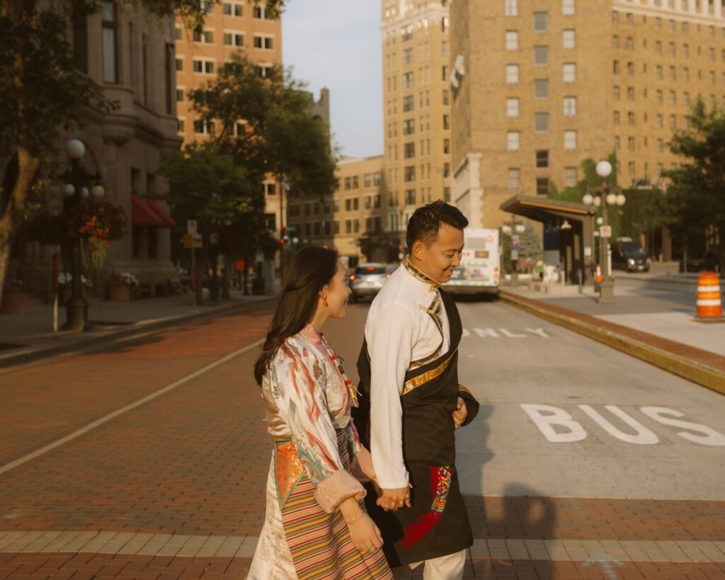 Image of a couple holding hands and crossing a city street. 