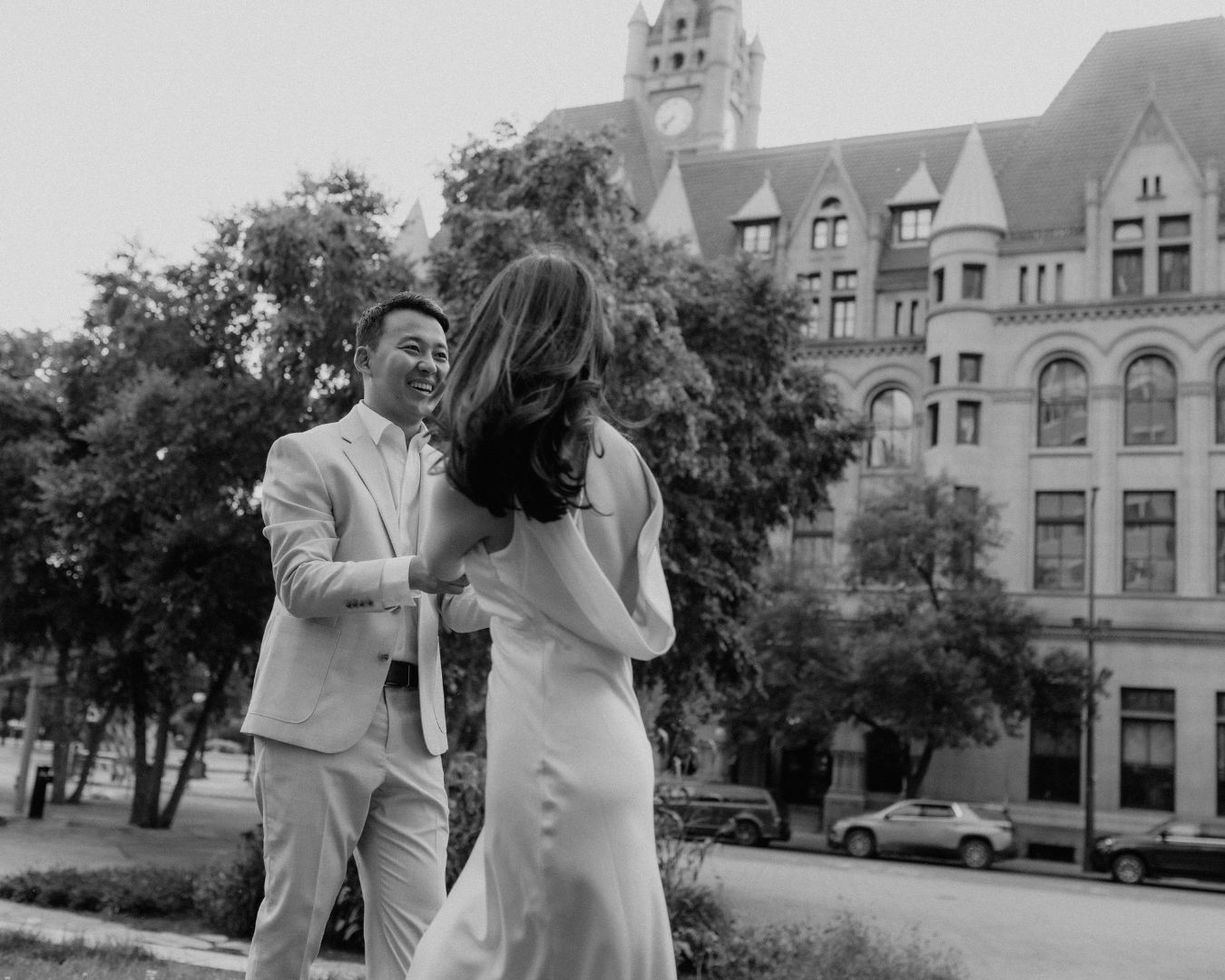 Black and white image of a couple holding hands and spinning in the city