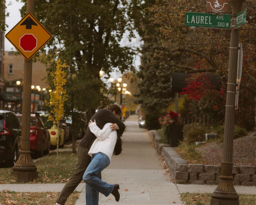 A couple on a street corner kissing and dipping. 